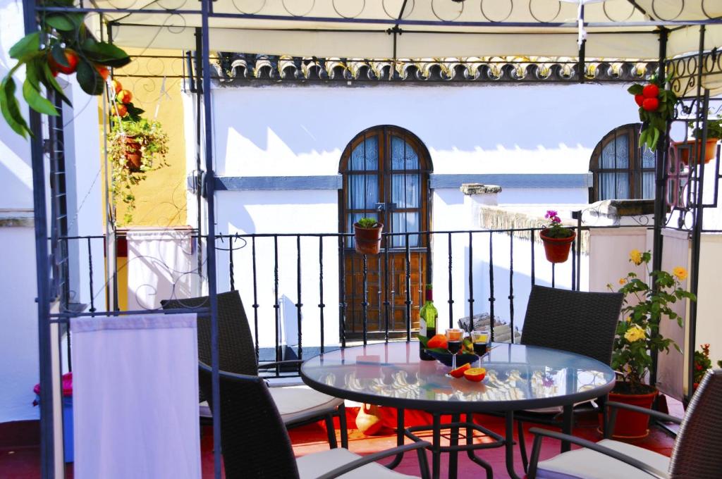 patio con mesa y sillas en el balcón en Pensión La Montoreña, en Sevilla