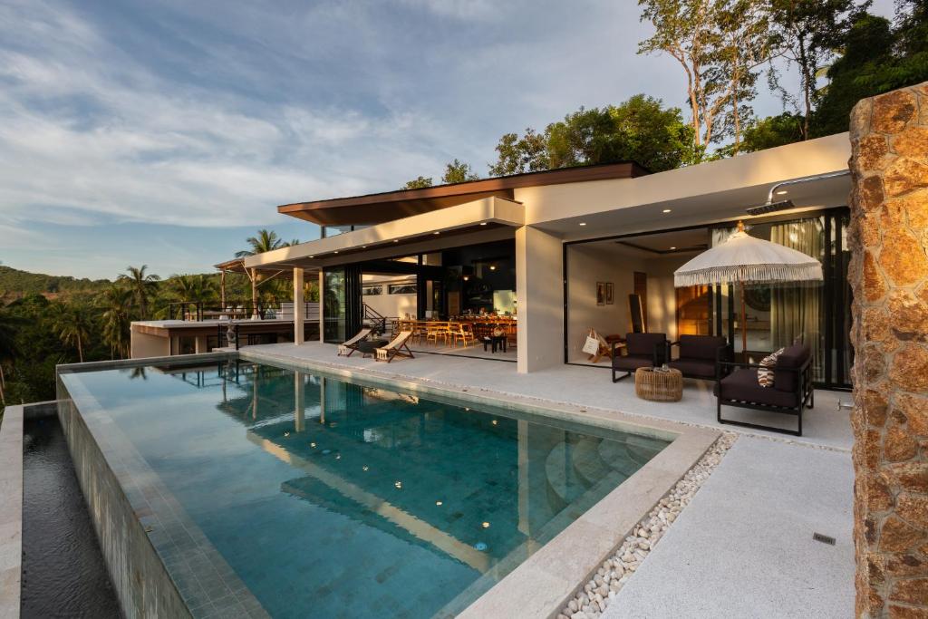 a house with a swimming pool in front of a house at Villa L3 by Stay Samui - Bohemian Chic in Koh Samui 