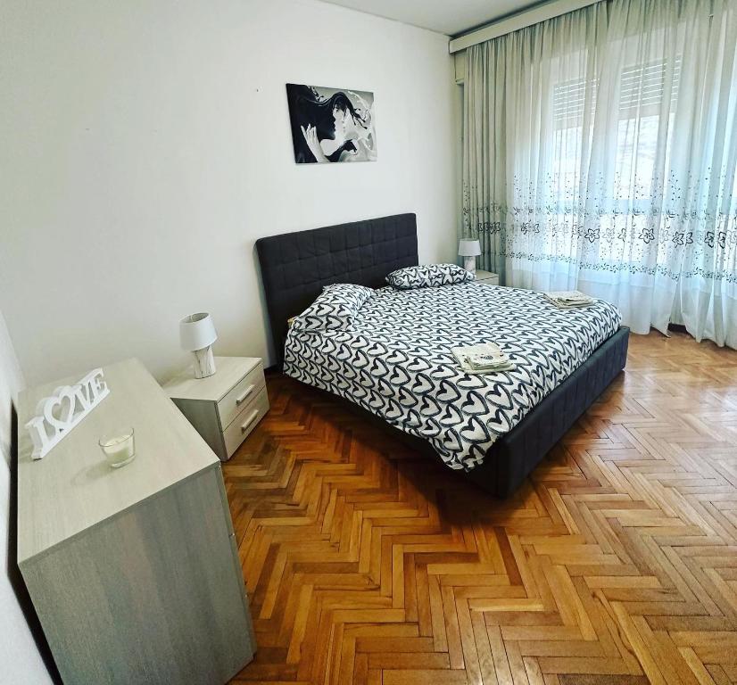 um quarto com uma cama e piso em madeira em Love Loft casa vacanza lecco em Lecco