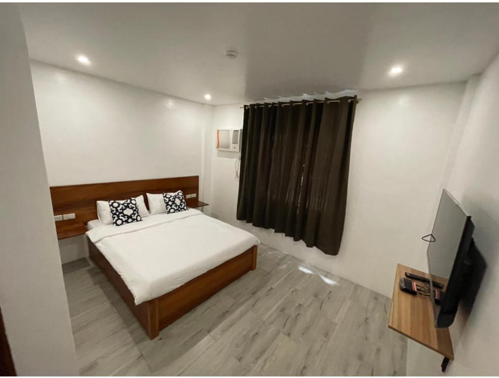 - une petite chambre avec un lit et une télévision dans l'établissement The Nook by Garolu, à Castillejos