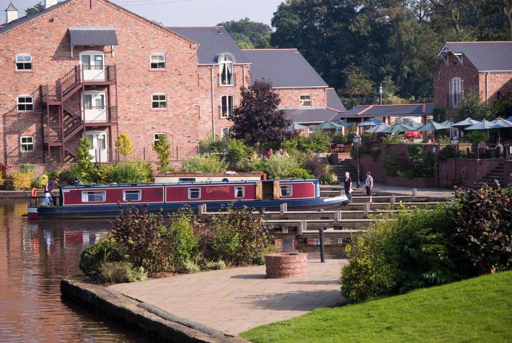 a train on a train track near a river at Lion Quays Resort in Chirk