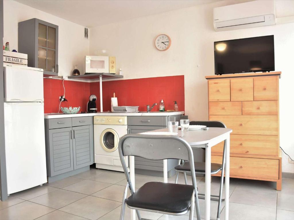 une cuisine avec une table et une machine à laver dans l'établissement Appt cosy avec parking, lave-linge, proche port à Gruissan - FR-1-229-792, à Gruissan