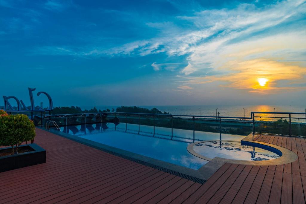 a swimming pool on top of a building with the sunset at Classic Regency in Alleppey