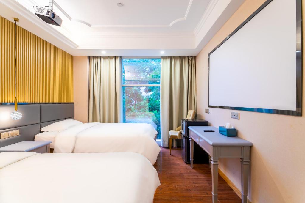 a hotel room with two beds and a projection screen at Puzzle Hotel - Zhongshan 8th Road Chenjiaci Subway Station Branch in Guangzhou