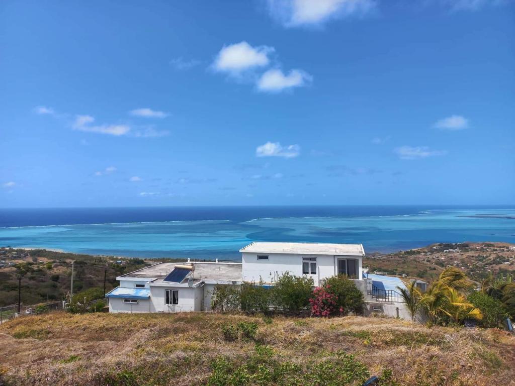 een huis op een heuvel met de oceaan op de achtergrond bij Ô Bercail du Sud chez Jeannette in Rodrigues Island