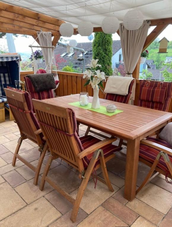 a wooden table and chairs on a patio at Ferienwohnungen Koch in Marburg an der Lahn