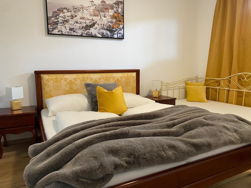 a bedroom with a bed with a blanket and yellow pillows at Dalila Appartements in Sankt Michael im Lungau