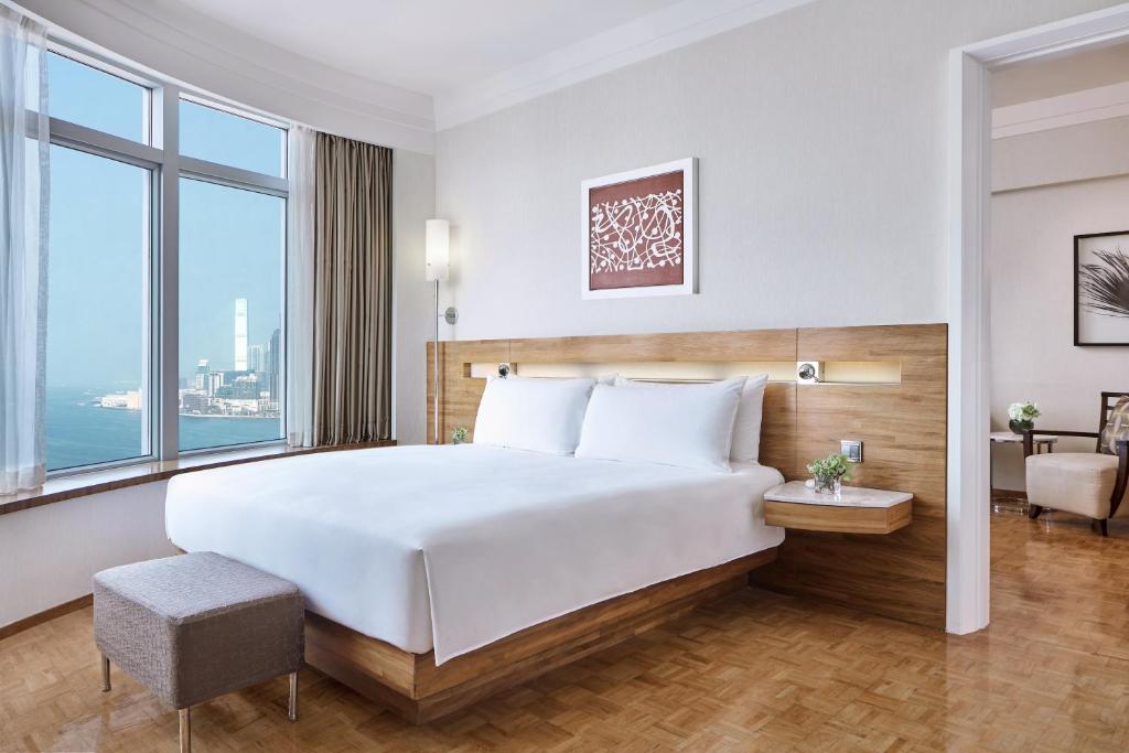 a bedroom with a large bed with a large window at Nina Hotel Causeway Bay in Hong Kong