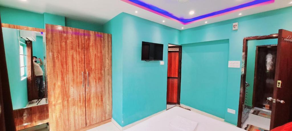 a room with blue and green walls and a mirror at Hotel Ananya Inn in Varanasi
