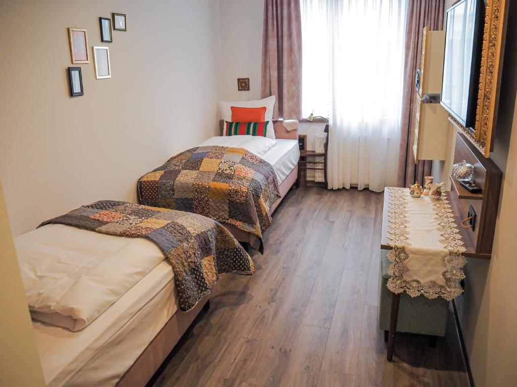 a hotel room with two beds and a table at Tante ALMA's Mülheimer Hotel in Mülheim an der Ruhr