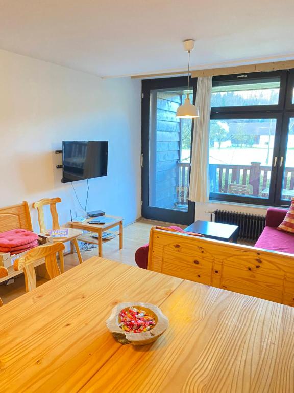 a living room with a table and a couch and a television at Apartment Steinwänd Top 7 in Grünau im Almtal