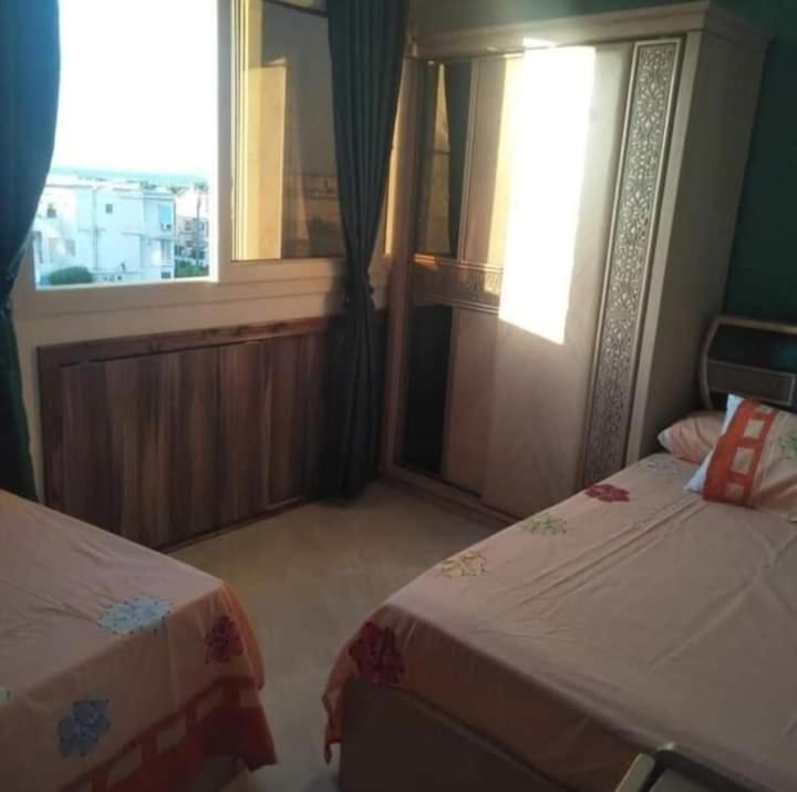um quarto de hotel com duas camas e uma janela em شاطئ المعموره em Alexandria