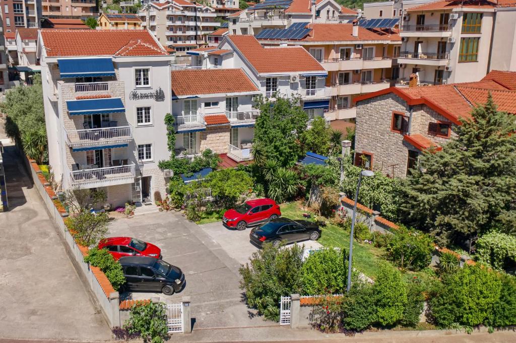 two cars parked in a parking lot in a city at Marinero Apartments in Budva