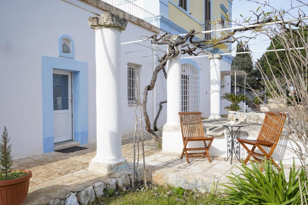 un patio con 2 sedie e un tavolo di fronte a una casa di Casina delle Rose - Levante a Polignano a Mare