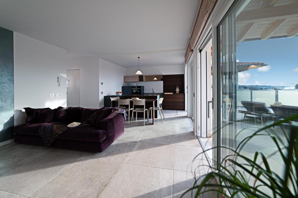 un soggiorno con divano viola e una cucina di APARTMENT YIN & YANG - Regarda Travel a Lazise