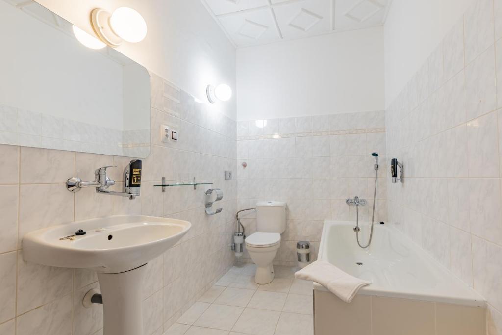 biała łazienka z umywalką i toaletą w obiekcie Hotel Amadeus w Czeskich Budziejowicach