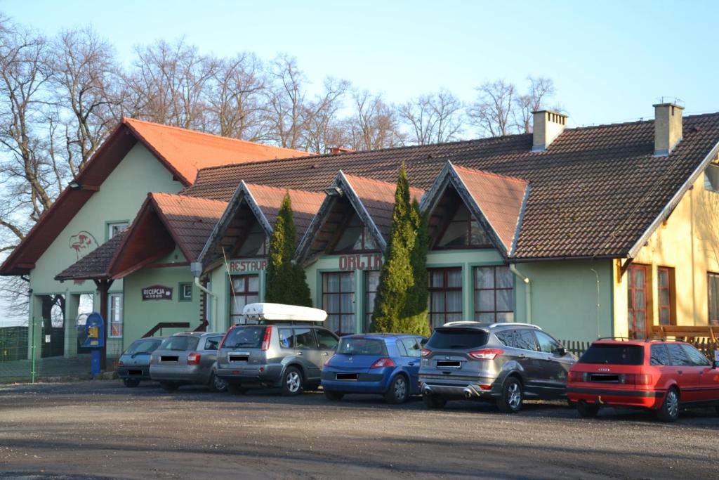 un groupe de voitures garées devant un bâtiment dans l'établissement Hotelik Orlik, à Legnickie Pole