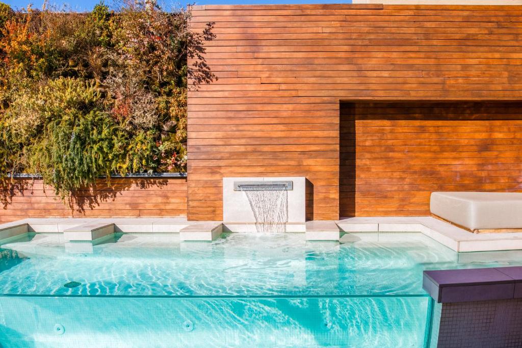 una piscina con un aro de baloncesto frente a una pared de madera en Hotel Well and Come, en Barcelona