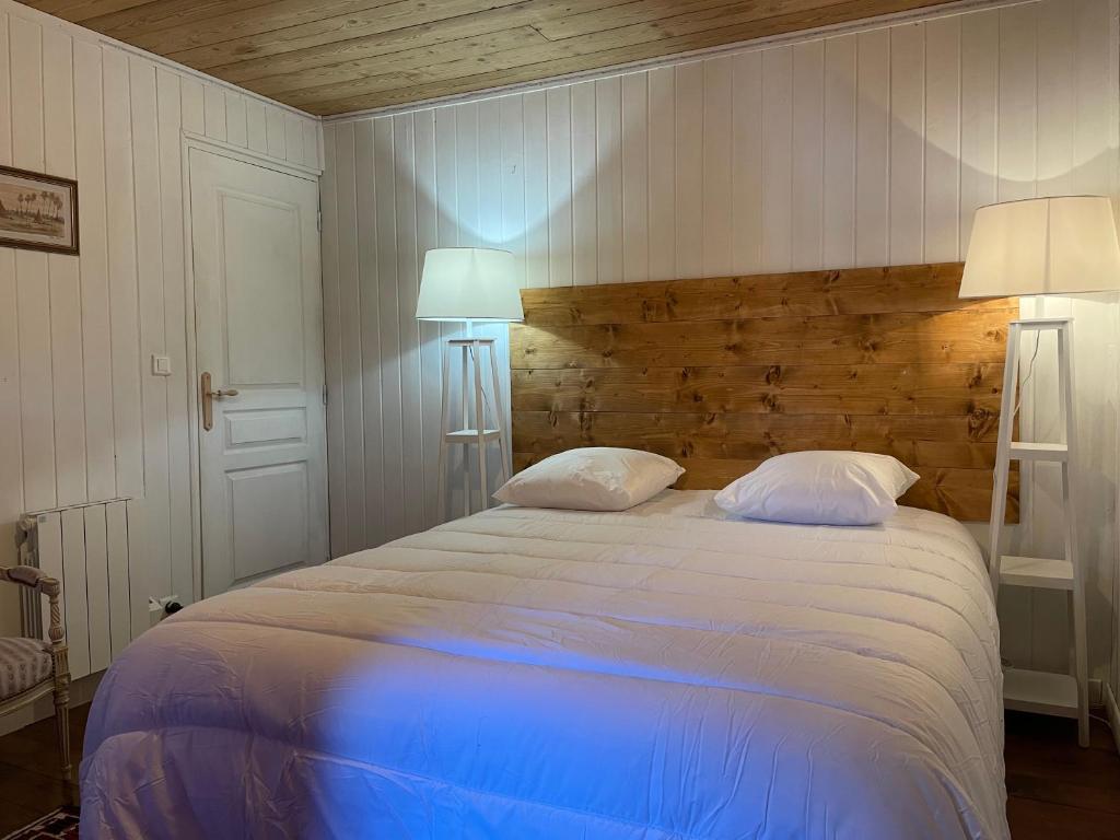 a bedroom with a large bed with two lamps at Le Chalet de Carole in Cadéac