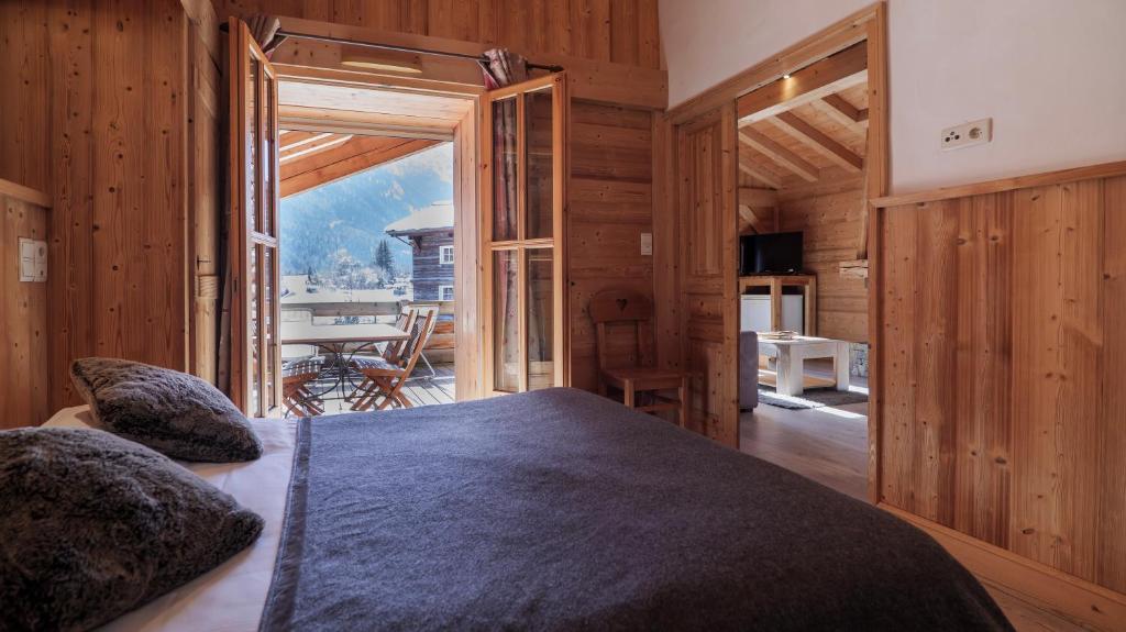 een slaapkamer met een groot bed in een kamer met houten wanden bij Hôtel Le Labrador in Chamonix-Mont-Blanc