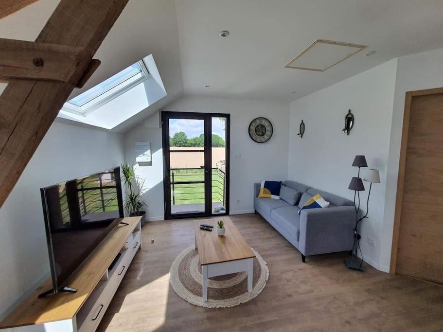 un salon avec un canapé et une table dans l'établissement Gîte au cœur de la campagne, à Saint-Gilles