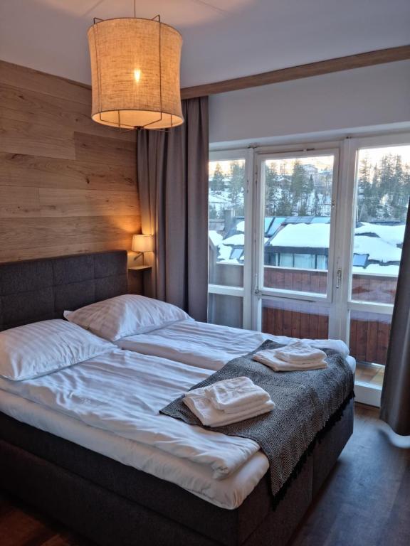 The Lodge at Bad Gastein في باد جاستاين: غرفة نوم بسرير ونافذة كبيرة