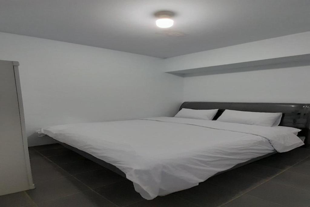 uma grande cama branca num quarto branco em SPOT ON 92236 Kediri Family Homestay em Medan