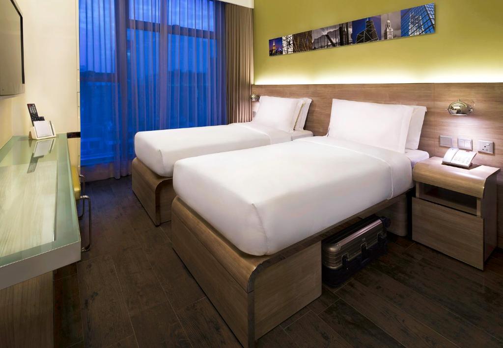Rúm í herbergi á Lodgewood by Nina Hospitality Mong Kok