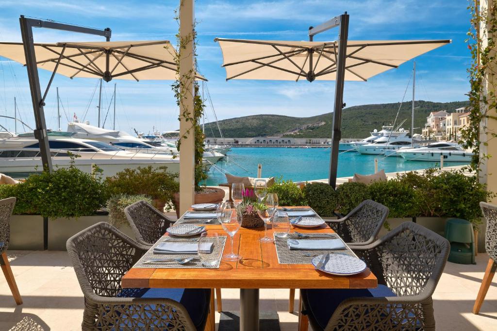 a wooden table on a patio with a view of a marina at The Chedi Luštica Bay in Tivat