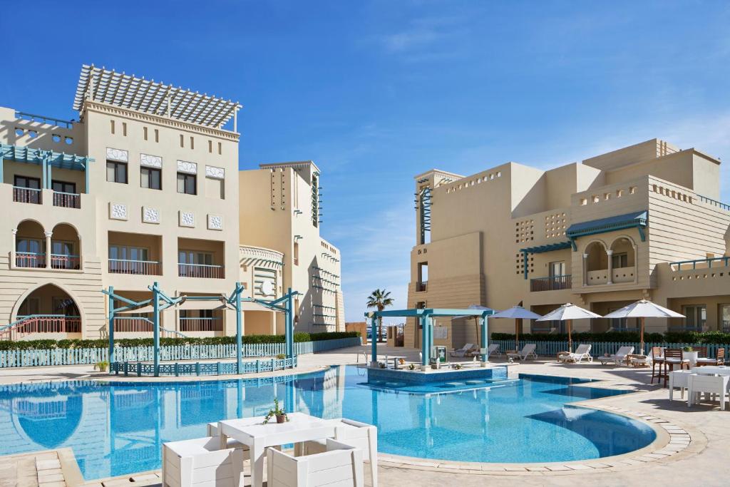 a swimming pool in front of a hotel at Mosaique Hotel El Gouna in Hurghada