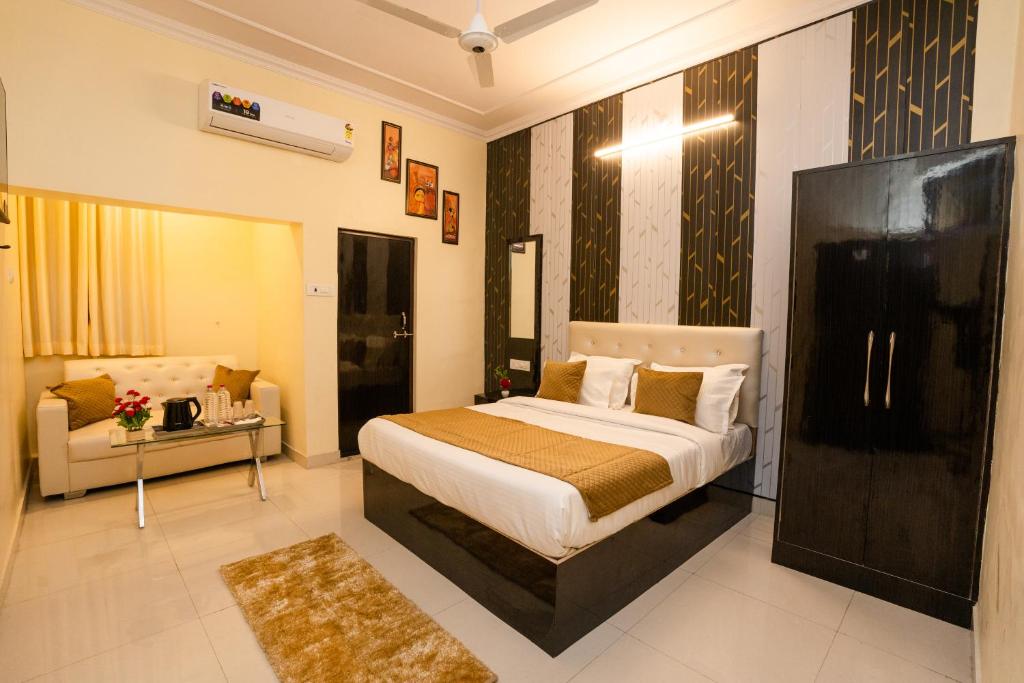 um quarto com uma cama e um sofá em Ventex Inn em Lucknow