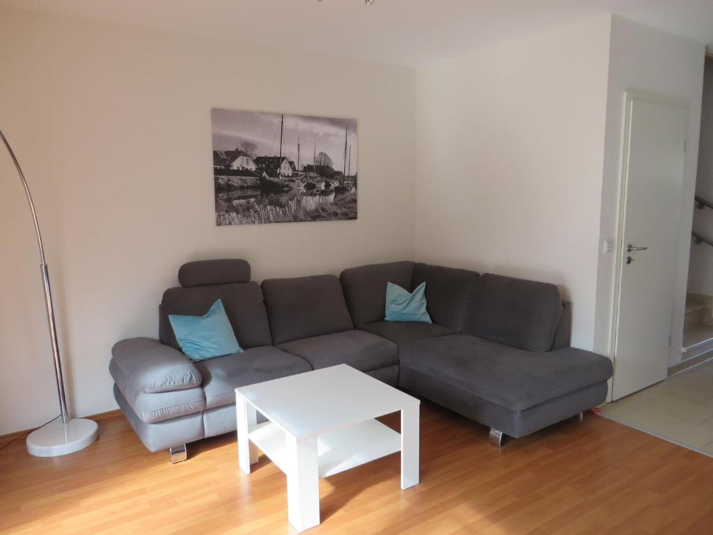 a living room with a couch and a table at NEU! Ferienhaus Küstenliebe in Harlesiel