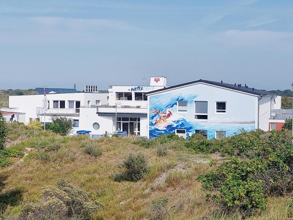 un edificio blanco con una pintura a un lado en CVJM Freizeithaus MS Waterdelle en Borkum