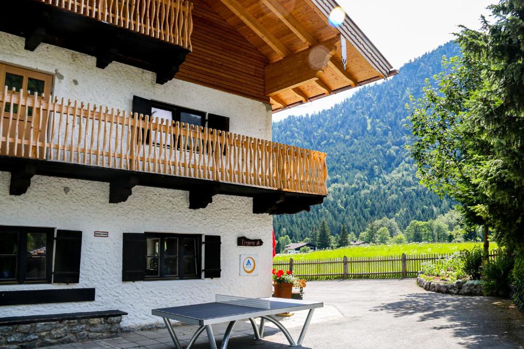 een picknicktafel voor een gebouw met een balkon bij Jugendherberge Schliersee in Schliersee