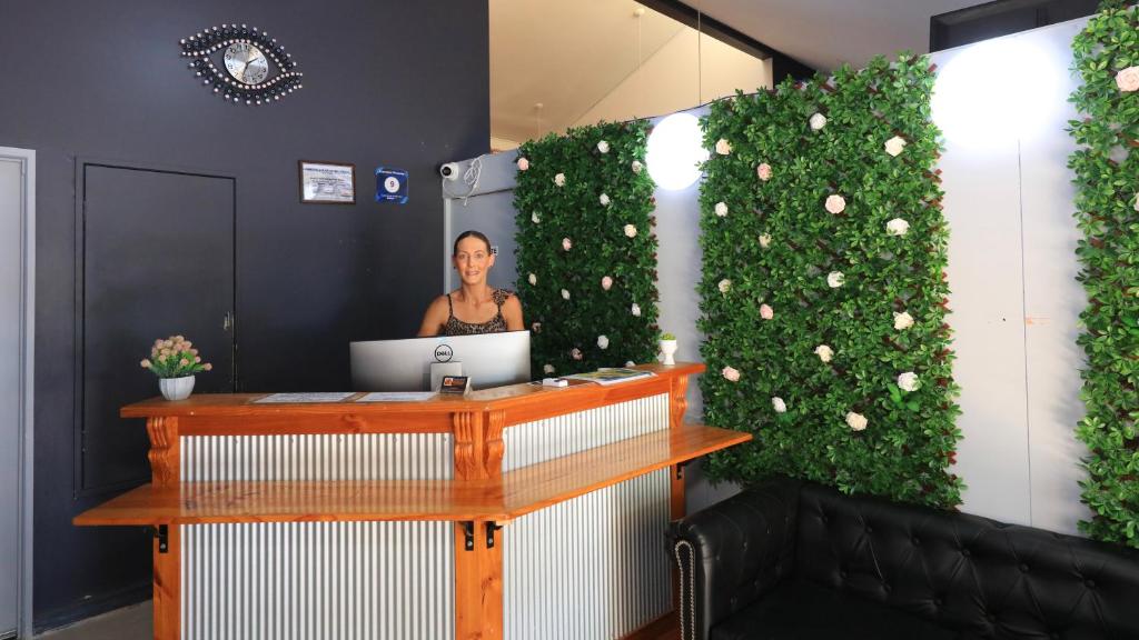 a woman standing behind a desk with a laptop at Executive Hideaway in Benalla