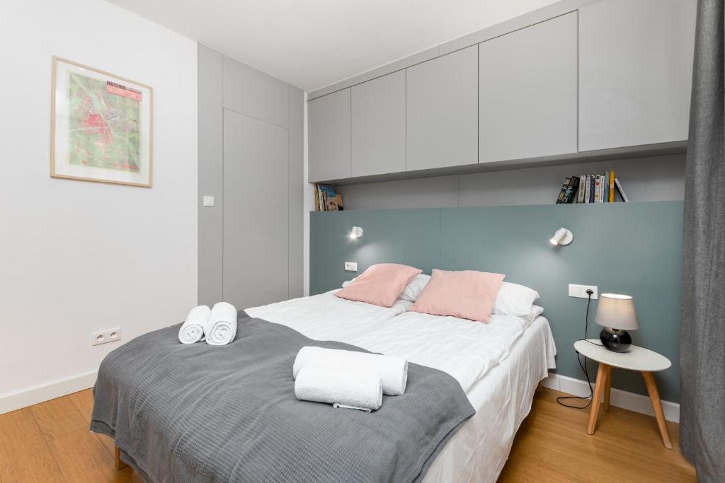 a bedroom with a large bed with white and pink at Hoża 36 by Homeprime in Warsaw