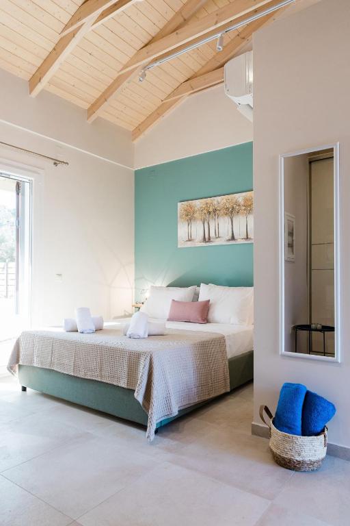 a bedroom with a large bed and a mirror at Seadrop Suites in Lefkada