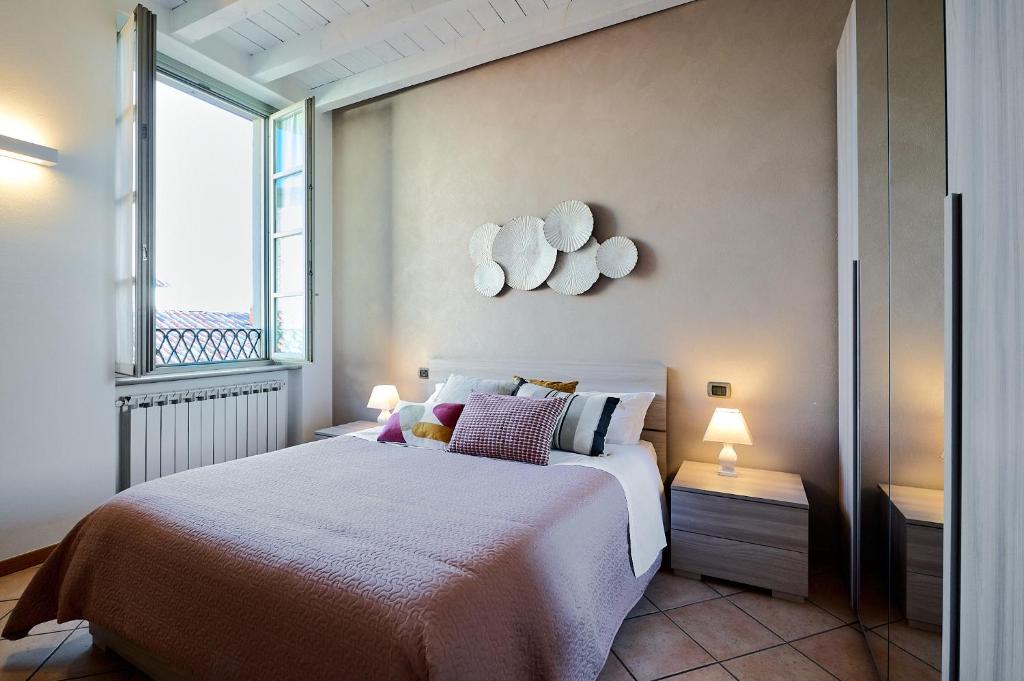 sypialnia z łóżkiem i dużym oknem w obiekcie Domus Dea Città Alta w Bergamo