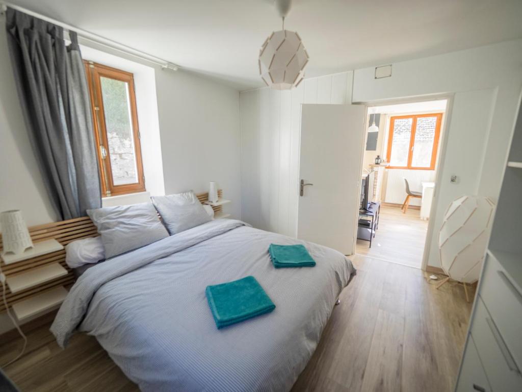 ein Schlafzimmer mit einem Bett mit zwei grünen Handtüchern darauf in der Unterkunft Charmant T2 in Aix-les-Bains
