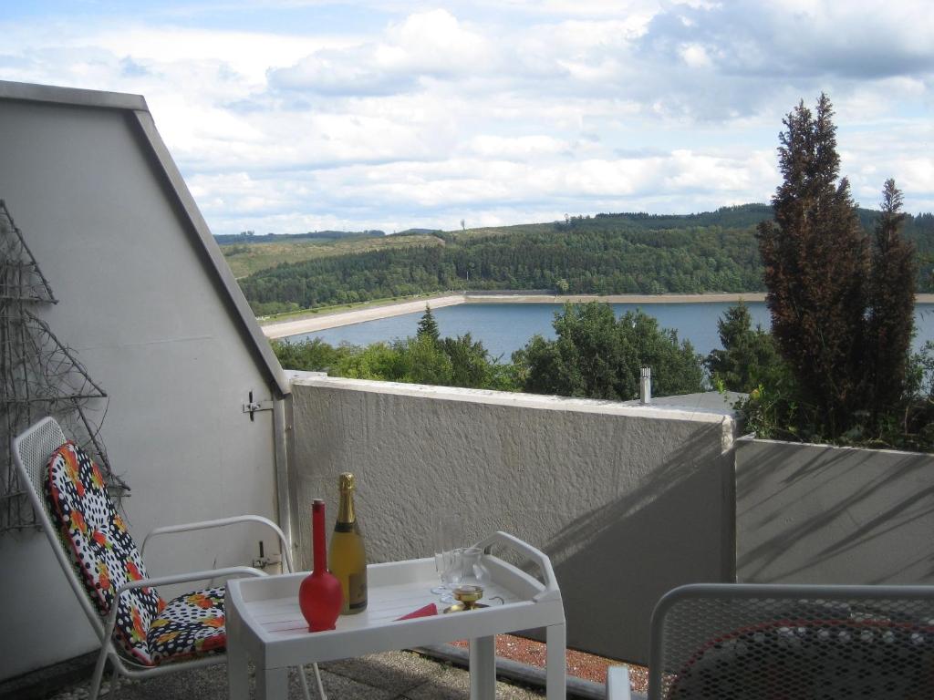 a balcony with a table and a view of a lake at Seeappartement Sorpeglück in Sundern