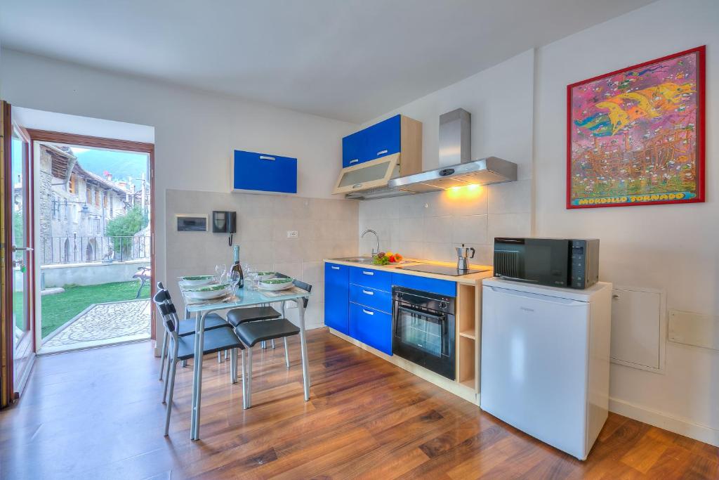een keuken met blauwe kasten en een tafel met stoelen bij Casa Umberto - Happy Rentals in Tenno