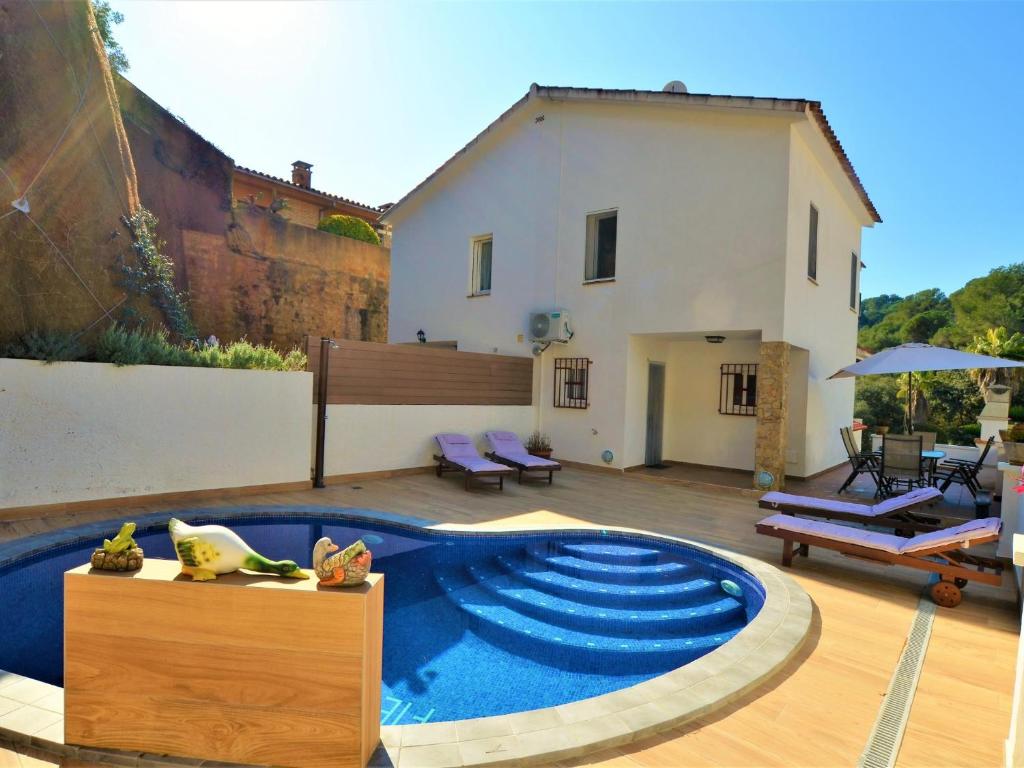 une arrière-cour avec une piscine et une maison dans l'établissement Villa Isabel Lloret de mar, à Lloret de Mar