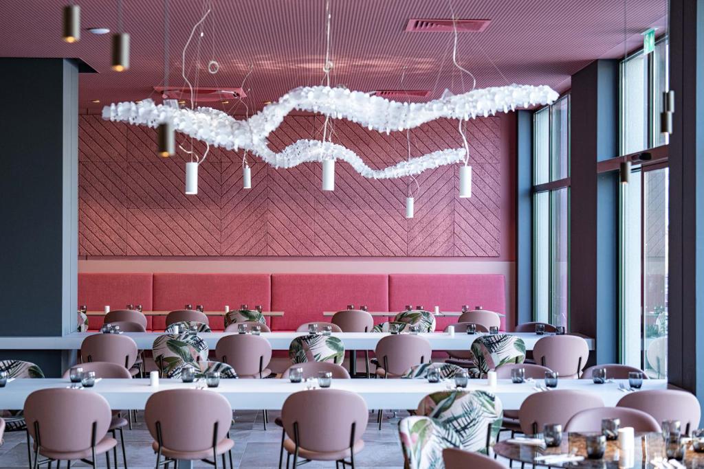 a room with tables and chairs and a pink wall at HVD Reina del Mar - Premium Spa Service & Free Parking in Obzor