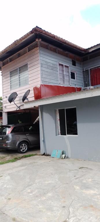 uma casa com um carro estacionado em frente em Marigold Roomstay em Labuan