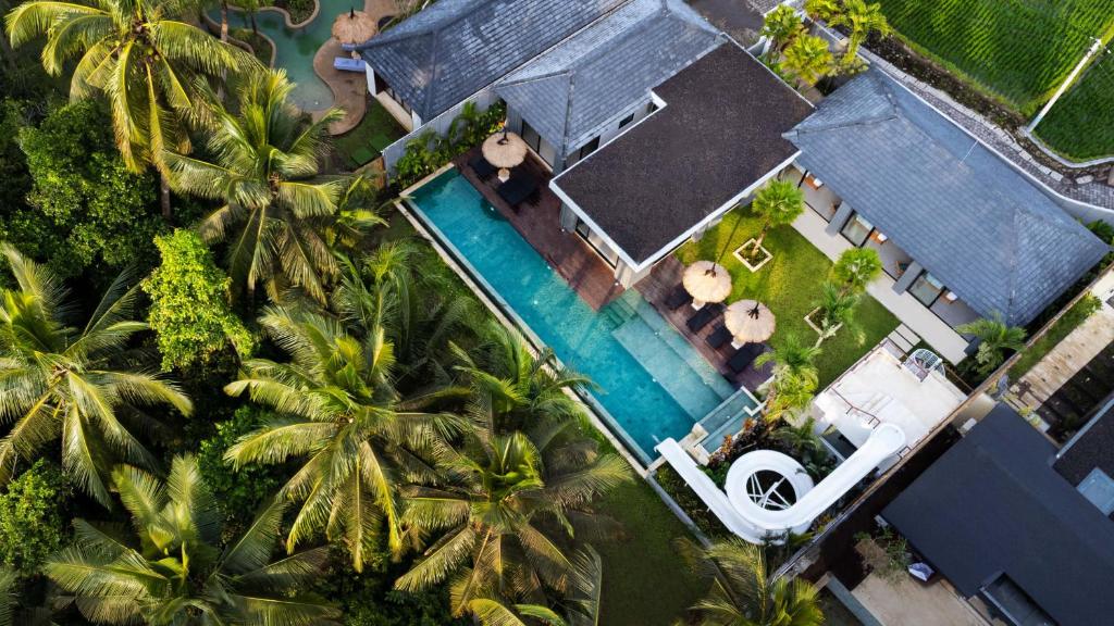 - une vue sur une maison dotée d'une piscine et de palmiers dans l'établissement Villa Slide by Bali Superhost, à Ubud