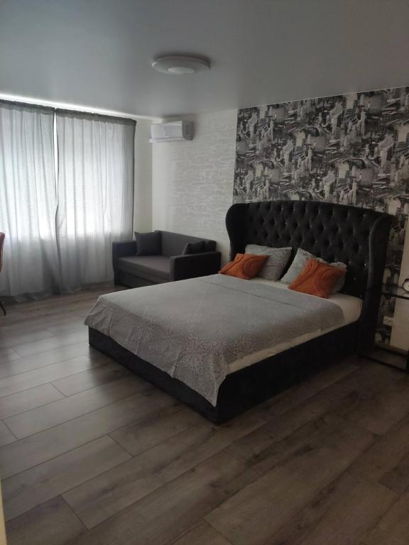 een slaapkamer met een groot bed en een bank bij Boulevard in Krementsjoek