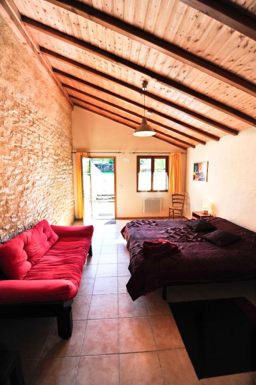 a living room with a red couch and a brick wall at Domaine Lagardelle Rocamadour in Rocamadour