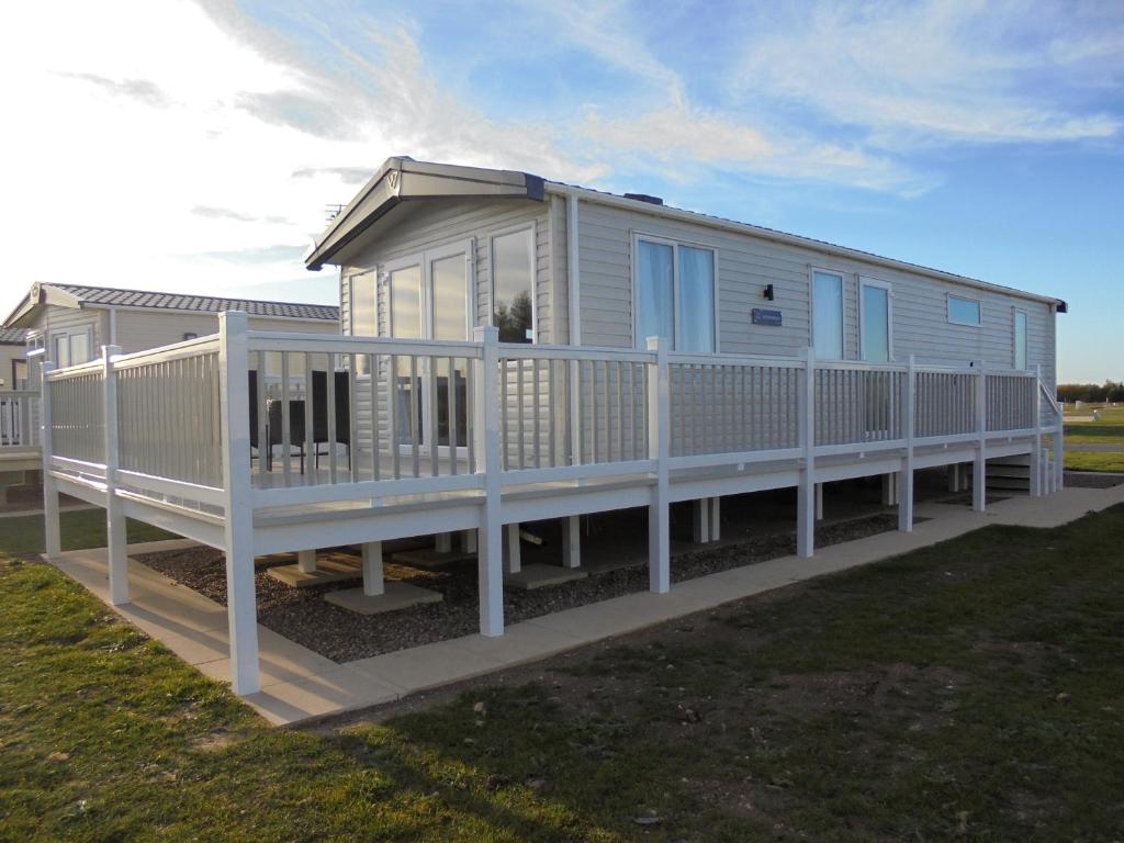a mobile home with a porch and a white railing at 6 Berth Grange Leisure Park Mablethorpe Stonewood in Mablethorpe