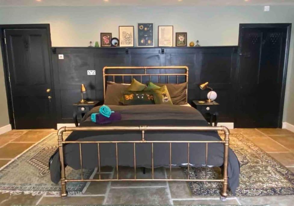 a bedroom with a metal bed with a black headboard at Clifton Georgian Townhouse, Inviting Ensuite Room & Plant Based Breakfast in Bristol