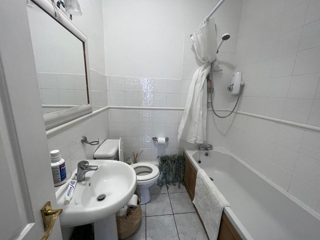 a bathroom with a sink and a toilet and a tub at Gorgeous 1 bed flat near Richmond Bridge. in Richmond
